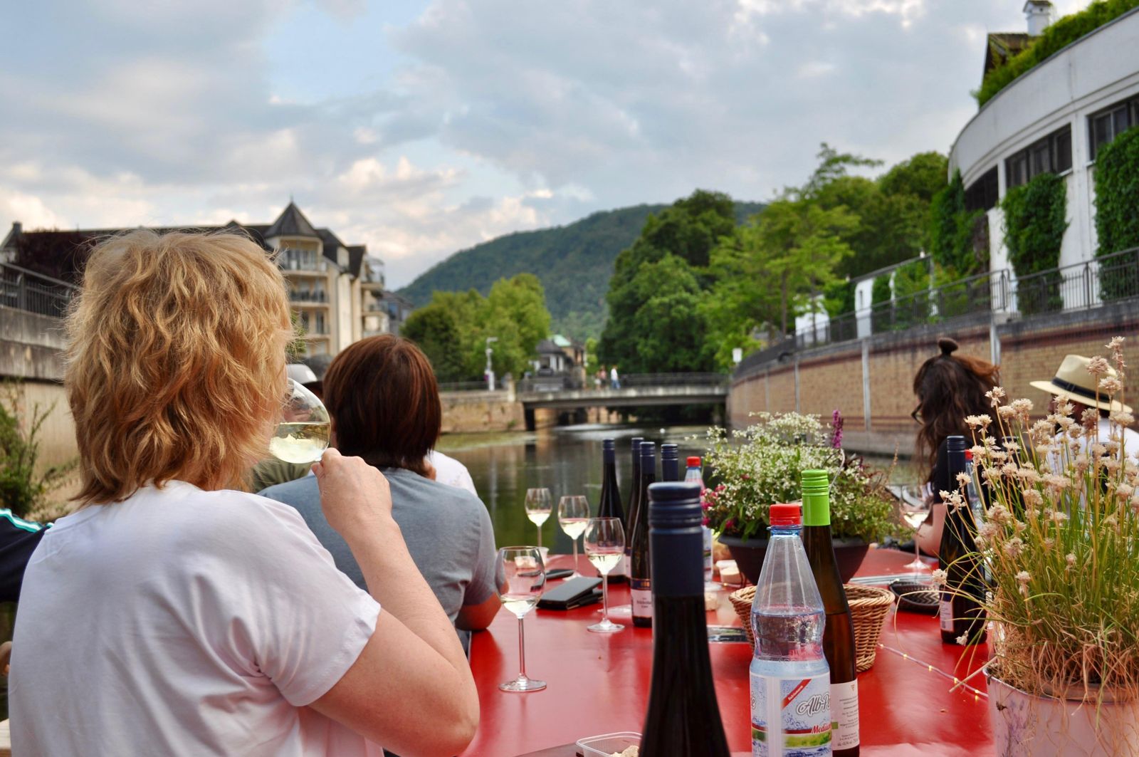 Gast genießt ein Glas Wein mit Blick über die Nahe auf die Kurstadt